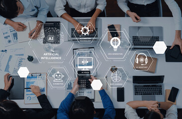 A group of professionals collaborates in a modern workspace, focusing on artificial intelligence concepts and data visualization to enhance business strategies and innovation. Trope