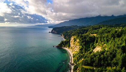 Coastal Landscape With Lush Green Forested Hills Meeting The Turquoise Ocean Under A Dramatic Cloudy Sky