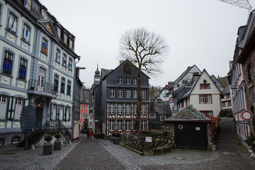 A picturesque view of a narrow cobblestone street in the historic center of Monschau, Germany.