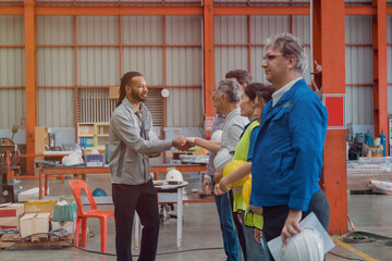 A group of engineers and staff members are discussing their work while working in a metal sheet and...