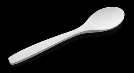 A light wooden spoon lays horizontally on a dark reflective surface