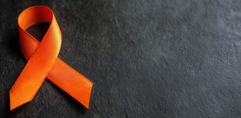 Orange ribbon representing awareness and support for multiple sclerosis, leukemia, and other related causes on a dark background