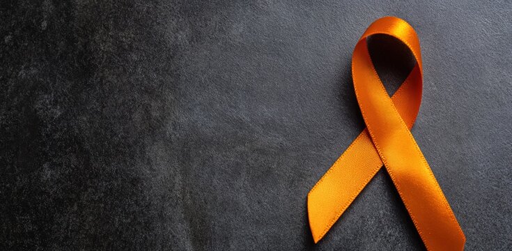 Orange awareness ribbon on dark background, representing support for multiple sclerosis, leukemia, and other related causes