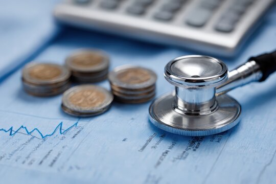 Stethoscope resting on a financial document with a graph, coins, and calculator, symbolizing healthcare budgeting and expenses - Powered by Adobe