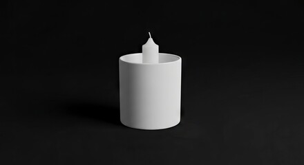 White candle in a white cylindrical holder on a dark gray surface