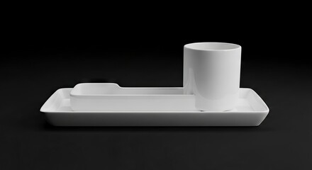 White ceramic mug and square dishes are arranged on a black surface
