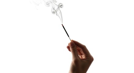 Hand holds incense stick smoke curls upwards on white background