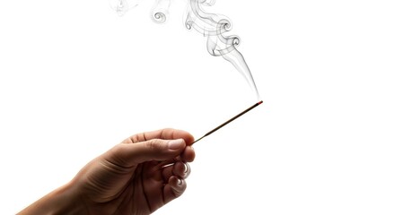 Hand holds incense stick smoke rises against white backdrop