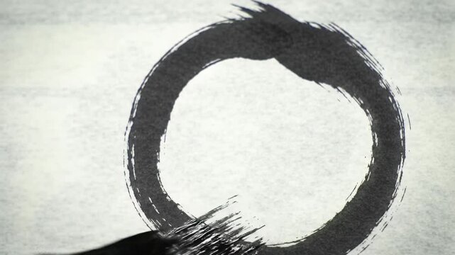 Extreme close-up: rough black sumi ink brushstroke draws, then subtly fades, an enso circle on pristine white rice paper with soft light. Concept of Zen sumi-e art