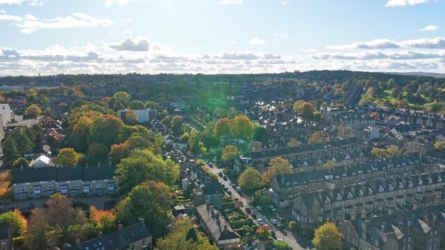 Drone cityscape of Harrogate Centre, with rows of historical terraces, autumn foliage, and garden suburb patterns visible under bright sky.