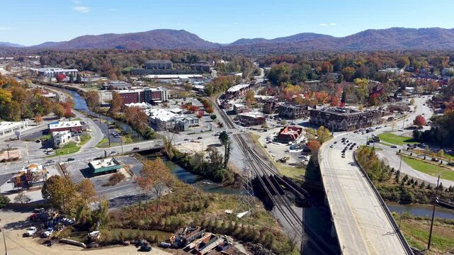 aerial push in to reveal asheville nc, north carolina skyline over hurricane helene debris one year after the storm