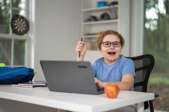 Kid learning at home with laptop and books. Child learn online using laptop at desk. Learning with homework in child room. E-learning on laptop. Kid learning at home. Back to school. - Powered by Adobe
