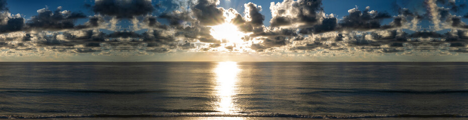Obraz premium Sunrise over ocean horizon panoramic. Dawn sky above sea banner. Beautiful seascape with sunset. Morning sun over calm water. Peaceful sunrise ocean view. Scenic ocean sunrise. Seascape with clouds.