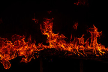Fototapeta premium Fire blaze flames on black background. Fire burn flame isolated, abstract texture. Flaming explosion with burning effect. Fire wallpaper, abstract art pattern with copy space.