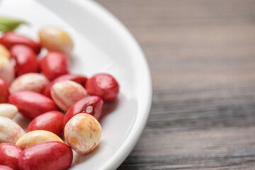Colorful beans of different varieties and sizes on white plate