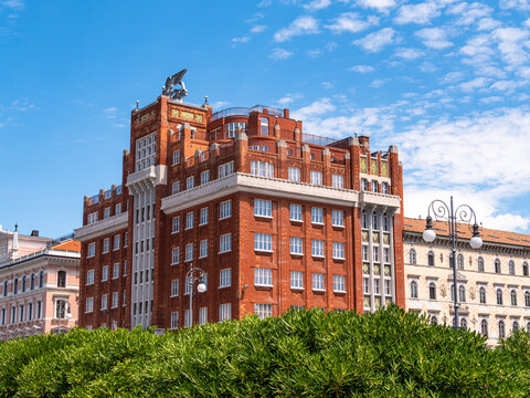 Historic Red Brick Building of insurance company Generali with Winged Statue in the town Trieste