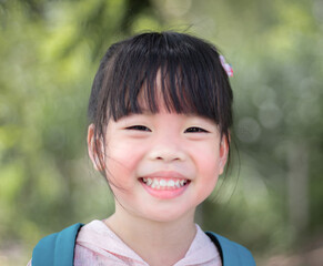 Portrait of a cute little asian girl smiling in the park
