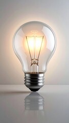 Illuminated light bulb glowing softly against a neutral background