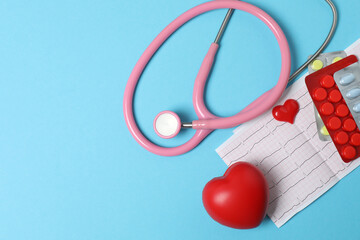 Medical stethoscope, red heart and cardiogram on a color background. ECG, pulse, myocardial infarction, cardiogram. The pulse trace on the cardiogram and the concept of the heart. Healthcare.Space for