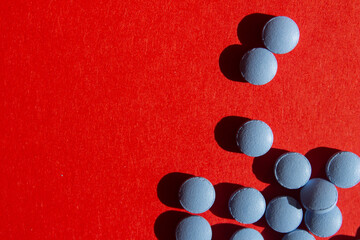 Blue pills on red background