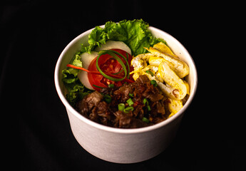 Sauteed Beef and Fried Egg Rice bowl with Salad Lettuce, Tomato and Cucumber 3/4 Degrees View with Black Background
