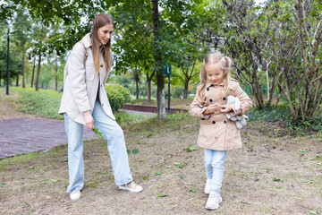 Obraz premium Woman spending time with young girl in autumn park
