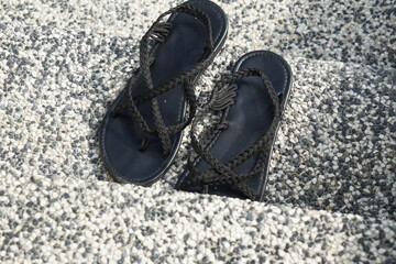 Black Braided Sandals on Concrete Steps