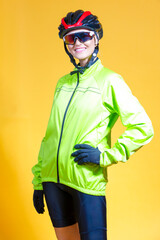 Portrait of Sporty Winsome Positive Female Cyclist in Vivid Amino Yellow Jersey Against Yellow Color Background.