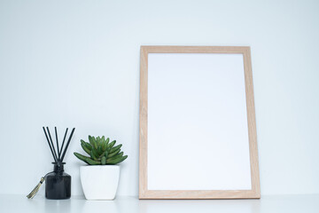 Vertical Wood Frame Mockup with Succulent Plant and Reed Diffuser on White Table
