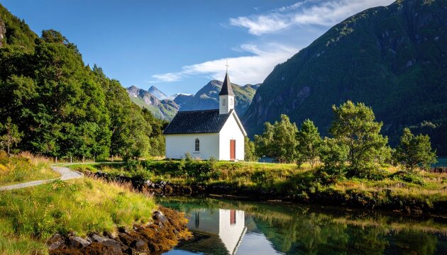 Small White Chapel With Steeple Stands Beside A Lush Green Forest And Tall Mountains With Clear Blue Sky Reflected In The Calm Water Below