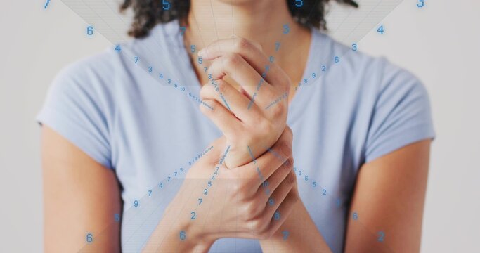 Woman wearing light blue short-sleeve shirt pressing left wrist in studio, with floating numbers