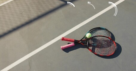Showing crossed tennis rackets resting on outdoor hard court with tennis ball, copy space © vectorfusionart