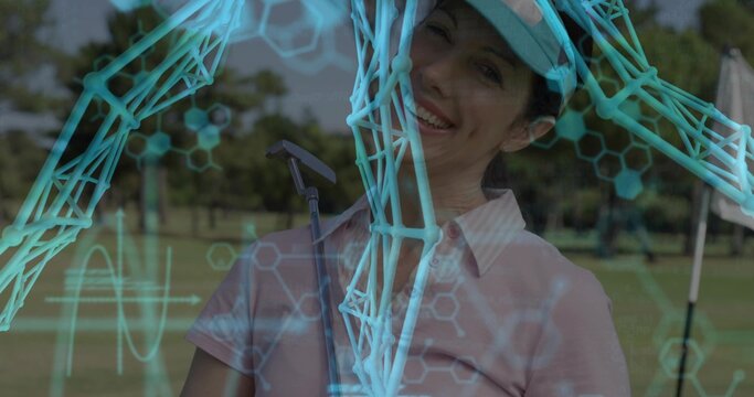 Smiling mature woman wearing golf visor gripping putter on fairway, with molecular hexagon graphics