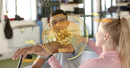 Therapist in pink top supporting patient lifting arm, rehab gym, with AR HUD and walking aid