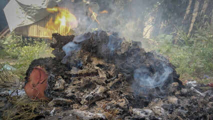 Burning dry trash with flames and smoke outdoors