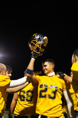Football player celebrating victory holding helmet high