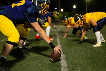 American football players preparing for a game at night