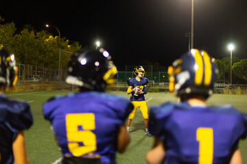 American football players practicing at night on field