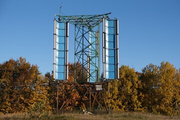 A vertical axis wind turbine (VAWT) on field in Kashubia, Poland, in autumn scenery and blue sky.