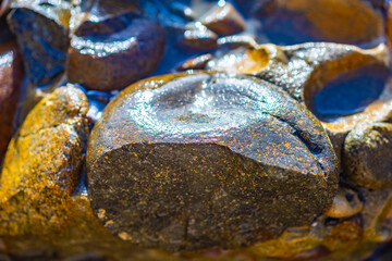 Abstract background of wet stones under the sun rays
