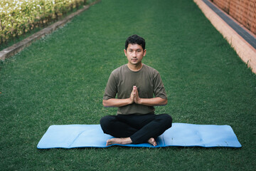 Asia man exercising practicing yoga in garden	