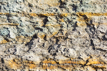 Abstract background of a gray rocky surface with yellow veins.
