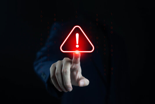 Businessman touching red warning alert icon on digital screen, symbolizing cybersecurity threat, system error, data breach, online risk, and technology protection in modern digital network.