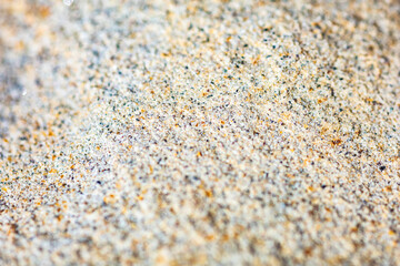 Abstract background of a stone surface with yellow and black particles, macro
