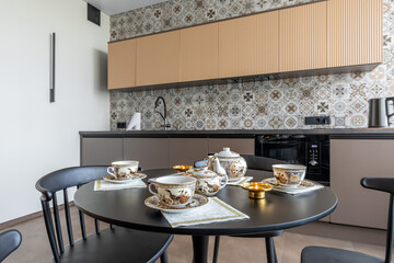 Porcelain Tea Set on Black Table in Modern Kitchen Interior