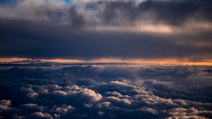 view from the airplane window to mountains clouds and blue sky