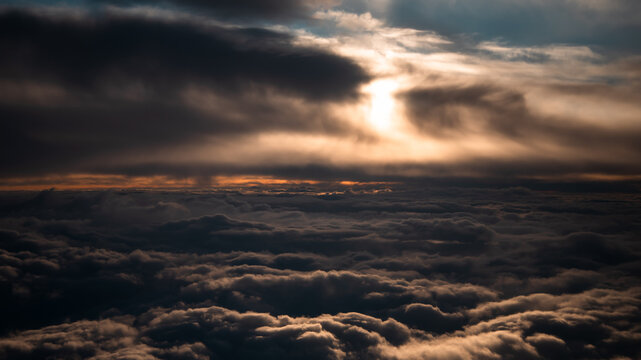 view from the airplane window to mountains clouds and blue sky - Powered by Adobe