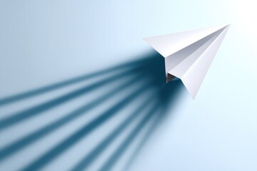 Paper airplane casting long shadow on white background concept for innovation creativity imagination and travel ideas