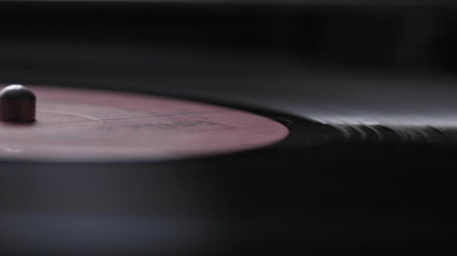 macro vinyl record spinning in turntable, vintage vinyl record playing music