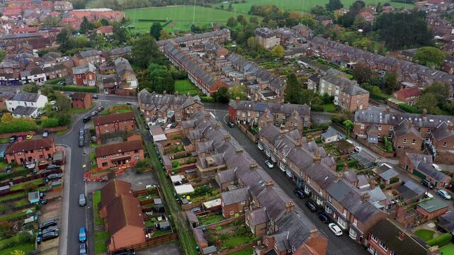 Aerial drone footage of the market town of Thirsk in North Yorkshire, England showing rows of victorian terrace houses on a gloomy dark bad weather rainy day in the winter time